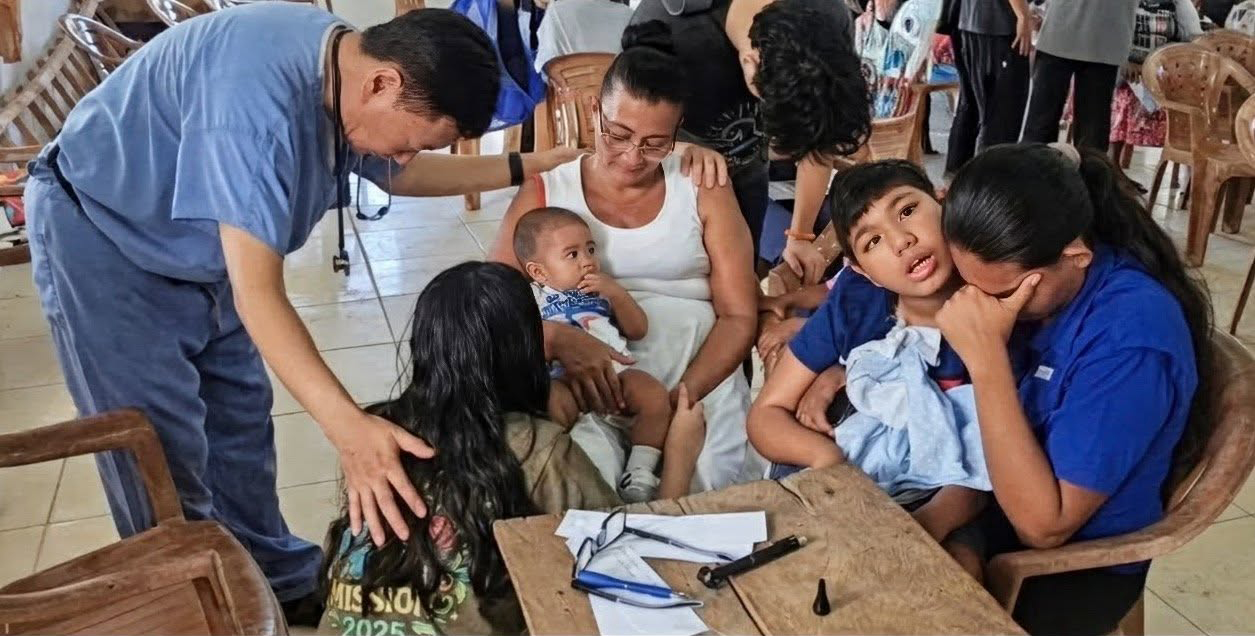 Healthcare professionals serving alongside local medical partners and caring for a patient and family in a community clinic