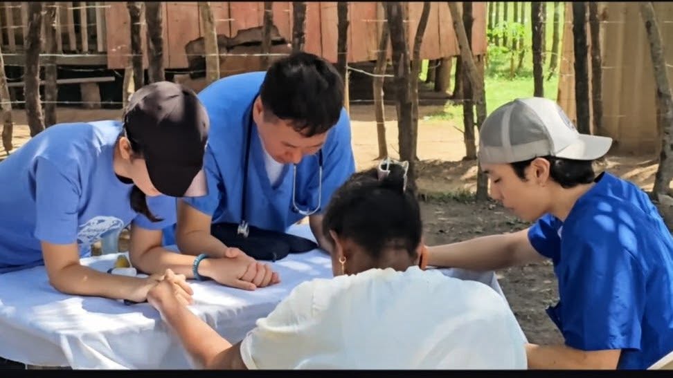 GMMA healthcare volunteers praying with a woman during a Honduras mission